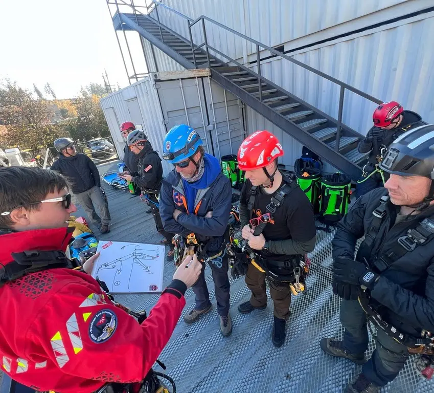 Rescue team receiving rooftop harness and rope briefing